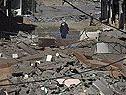 Ein Mann läuft durch zerstörte Häuser