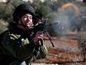 Ein israelischer Soldat feuert auf auf palästinesische Demonstranten Ein israelischer Soldat feuert auf auf palästinesische Demonstranten
