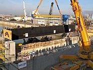 Ein 500-Tonnen-Kran hebt eines der riesigen Torelemente für den Hafen Freudenau