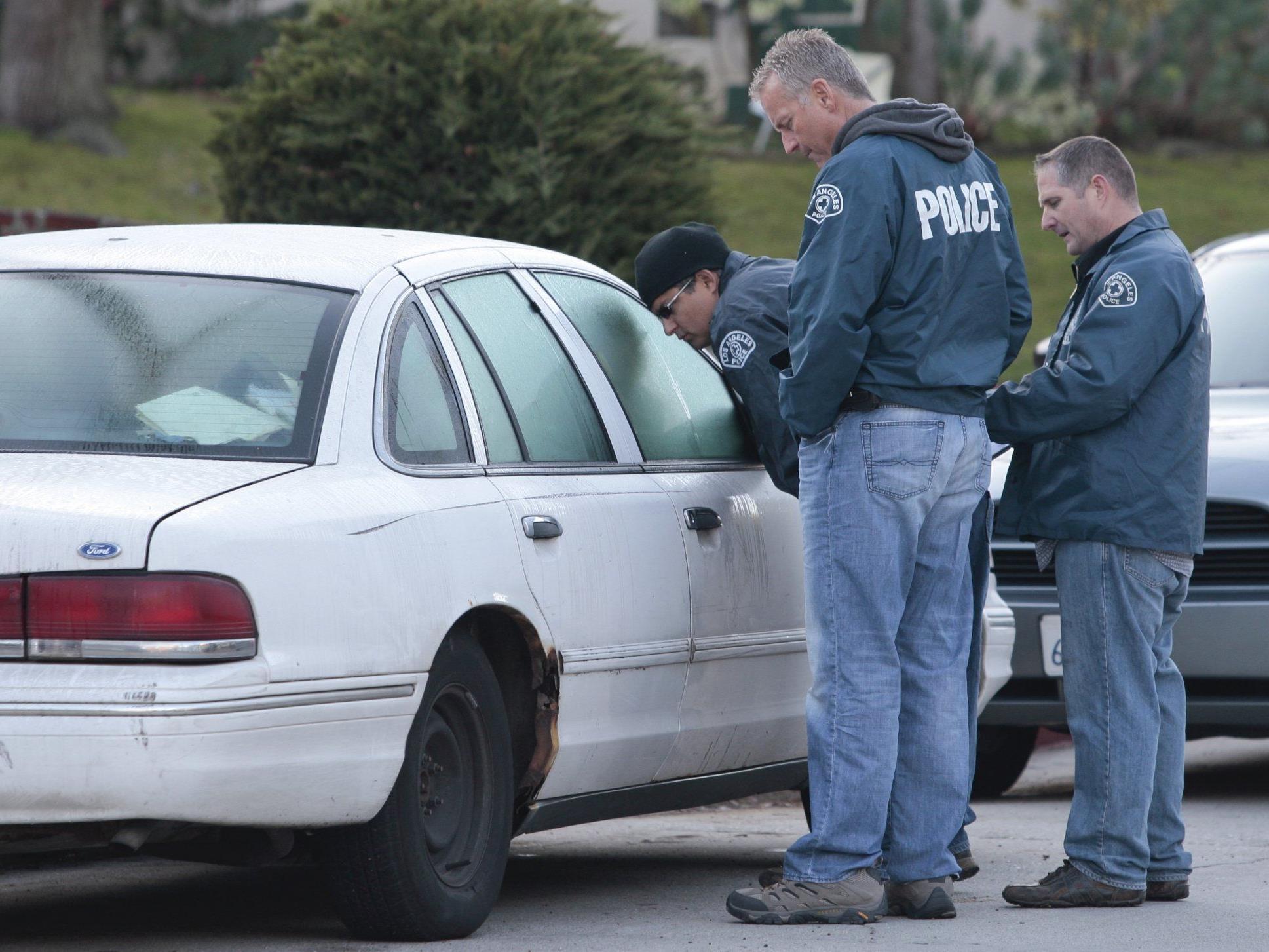 Die Polizei untersucht ein Fahrzeug nahe dem Hollywood-Schriftzug.