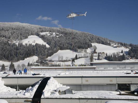Im Minutentakt fliegt der Hubschrauber Schnee vom Flachdach des Skiherstellers Atomic in Altenmarkt.