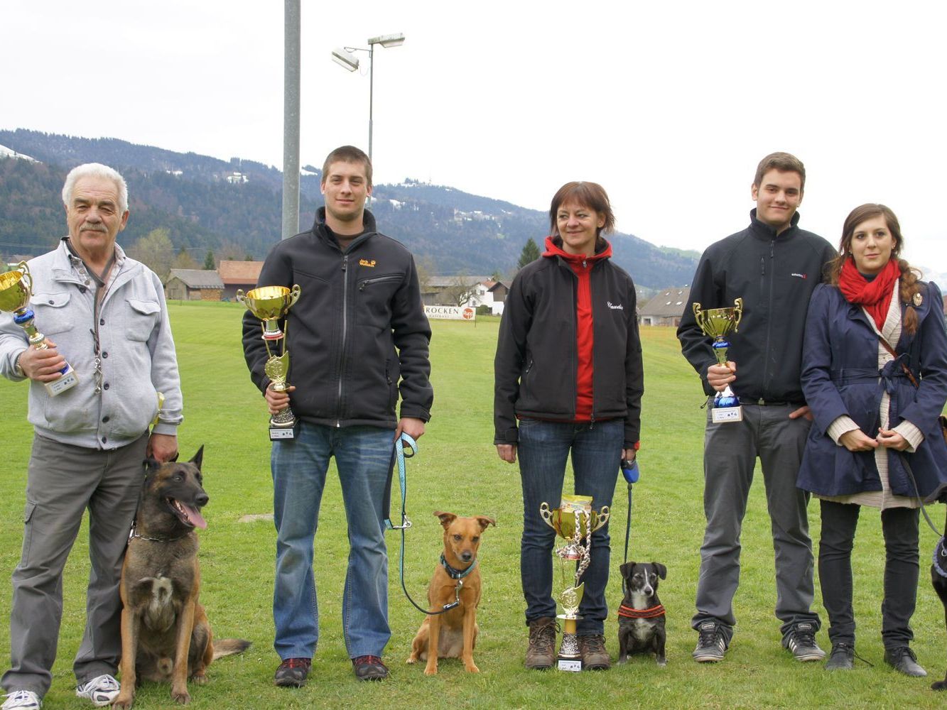 Die strahlenden Gewinner mit ihren siegreichen Hunden Die strahlenden Gewinner mit ihren siegreichen Hunden