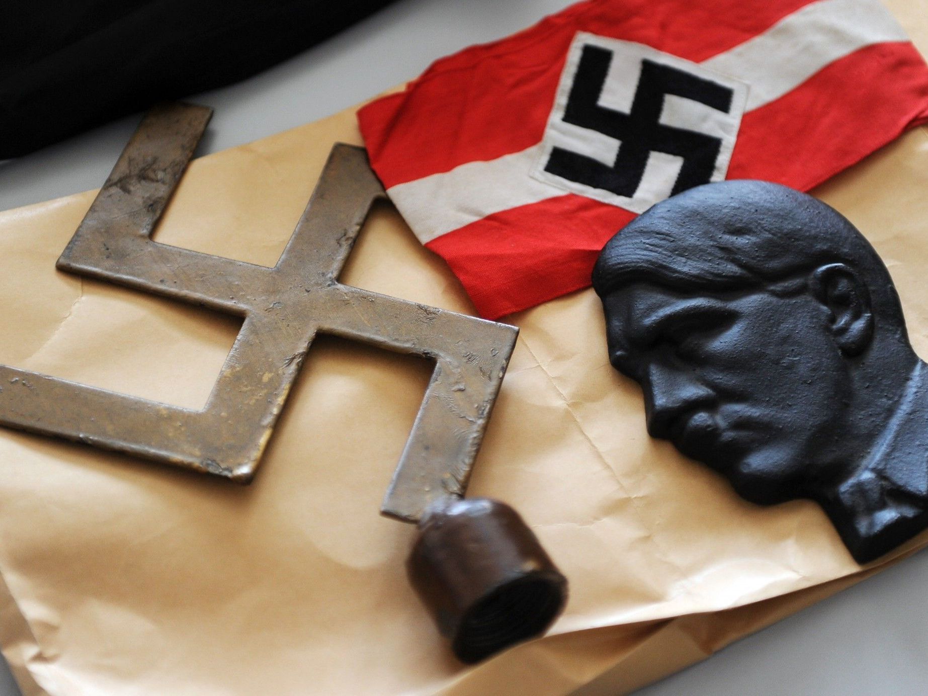 Bei den Razzien beschlagnahmte Gegenstände, darunter ein Hakenkreuz und eine Abbildung von Adolf Hitler. Bei den Razzien beschlagnahmte Gegenstände, darunter ein Hakenkreuz und eine Abbildung von Adolf Hitler.