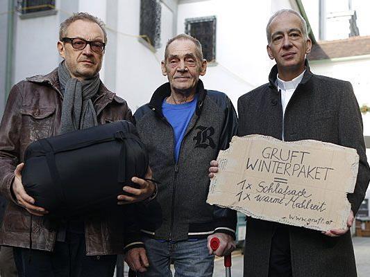 Kabarettist Josef Hader, der von Obdachlosigkeit betroffene Rudi und Caritasdirektor Michael Landau bewerben die Aktion "Gruft Winterpaket"