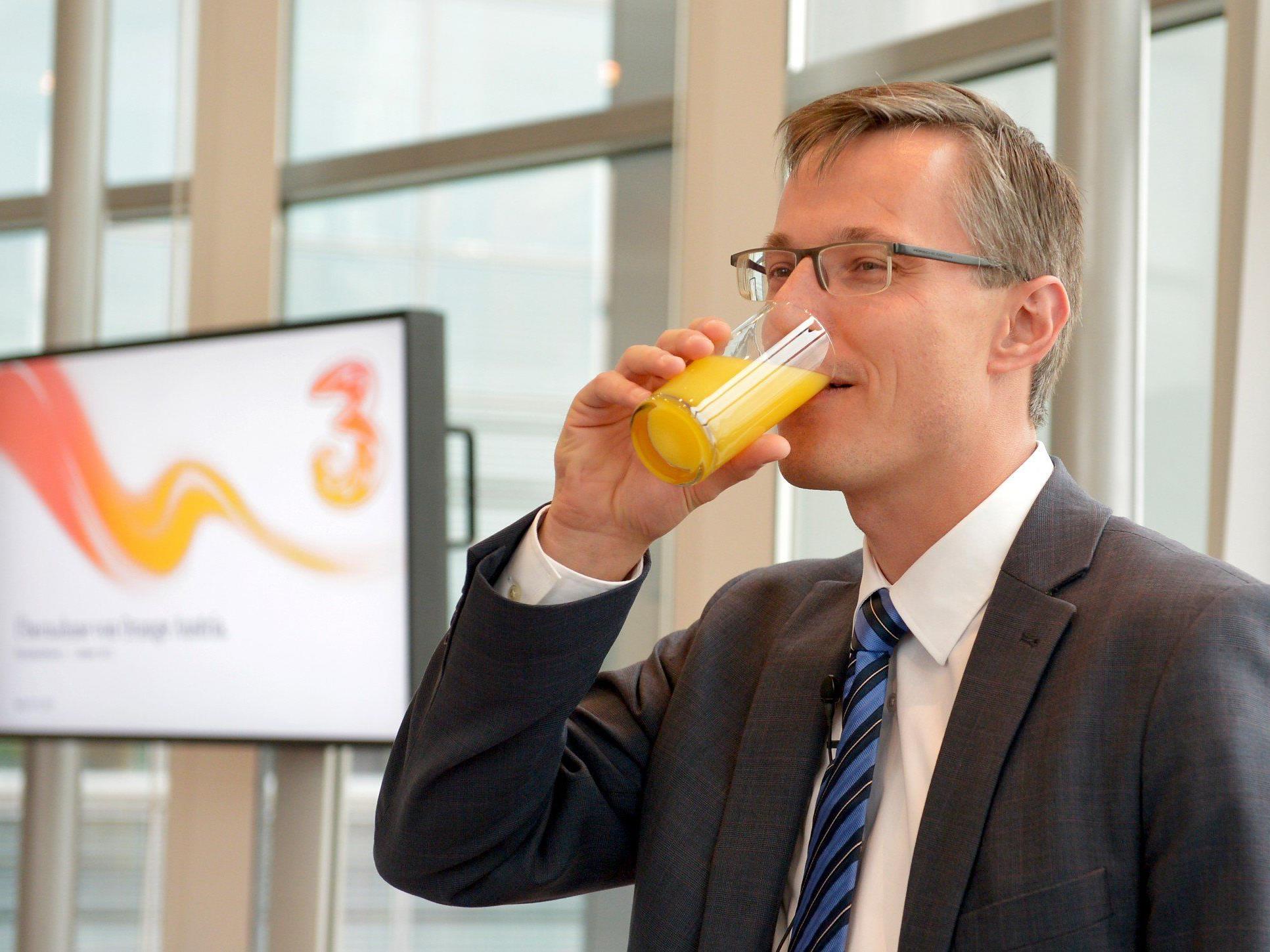 "Drei"-CEO Jan Trionow mit einem Glas Orangensaft bei einer Pressekonferenz zur Übernahme.