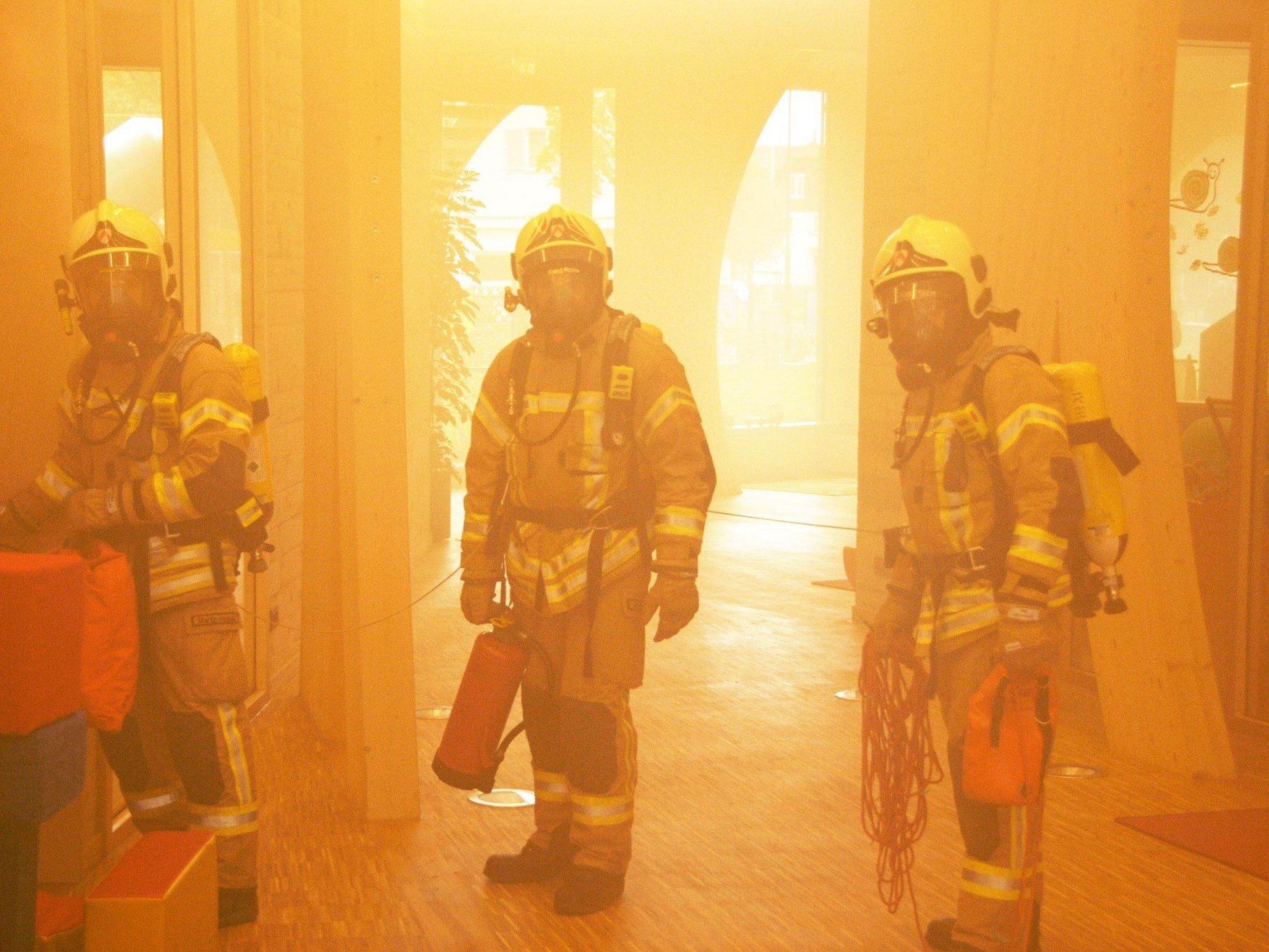 Höchster Feuerwehrmänner mit schwerem Atemschutz im Übungs-Nebel des KinderCampus Höchster Feuerwehrmänner mit schwerem Atemschutz im Übungs-Nebel des KinderCampus