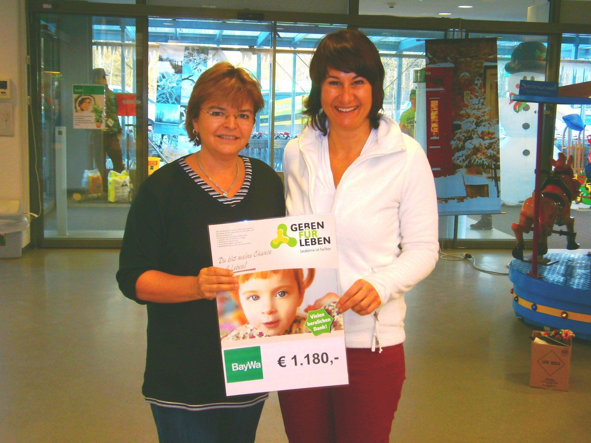 Silvia Burkhart (BayWa) und Susanne Marosch - Durch das Netzgeld vom Christbaumverkauf und den Verpackungsservice von Geschenken wurde ein Spendenbetrag von 1180 Euro eingenommen. Silvia Burkhart (BayWa) und Susanne Marosch - Durch das Netzgeld vom Christbaumverkauf und den Verpackungsservice von Geschenken wurde ein Spendenbetrag von 1180 Euro eingenommen.