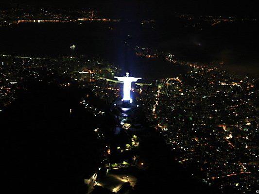 Christus-Statue blickt auf wenig illuminiertes Rio