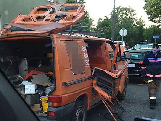 Einsatzkräfte beim beschädigten Auto an der Unglücksstelle in Wien-Favoriten