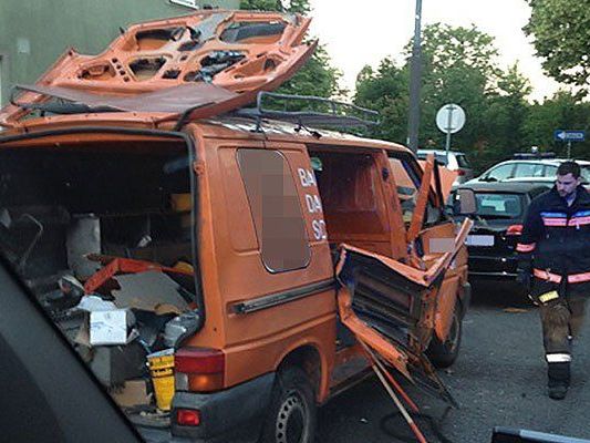 Einsatzkräfte beim beschädigten Auto an der Unglücksstelle in Wien-Favoriten