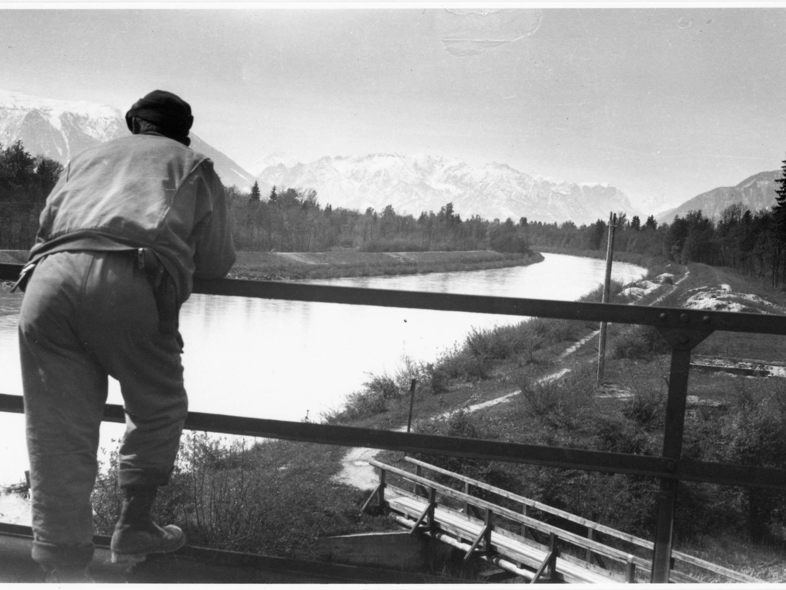 Ein amerikanischer Soldat blickt am 4. Mai 1945 von der Eisenbahnbrücke über die Saalach in Richtung Untersberg, hinter dem das Wettrennen um die Befreiung des Obersalzburg im Gang ist.