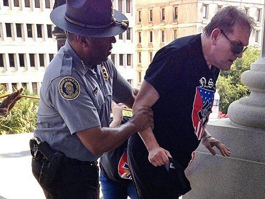 Polizist Leroy Smith stützt den Anhänger des Ku Klux Klan. Polizist Leroy Smith stützt den Anhänger des Ku Klux Klan.