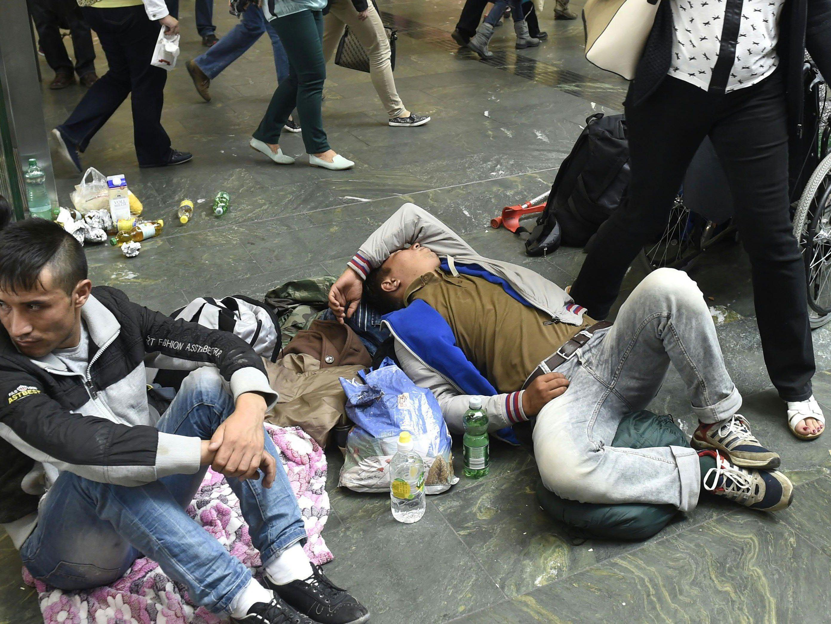 Erschöpfte Flüchtlinge am Bahnhofsboden.