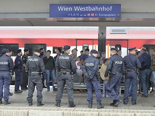 Flüchtlinge und Polizeibeamte auf dem Bahnsteig am Wiener Westbahnhof