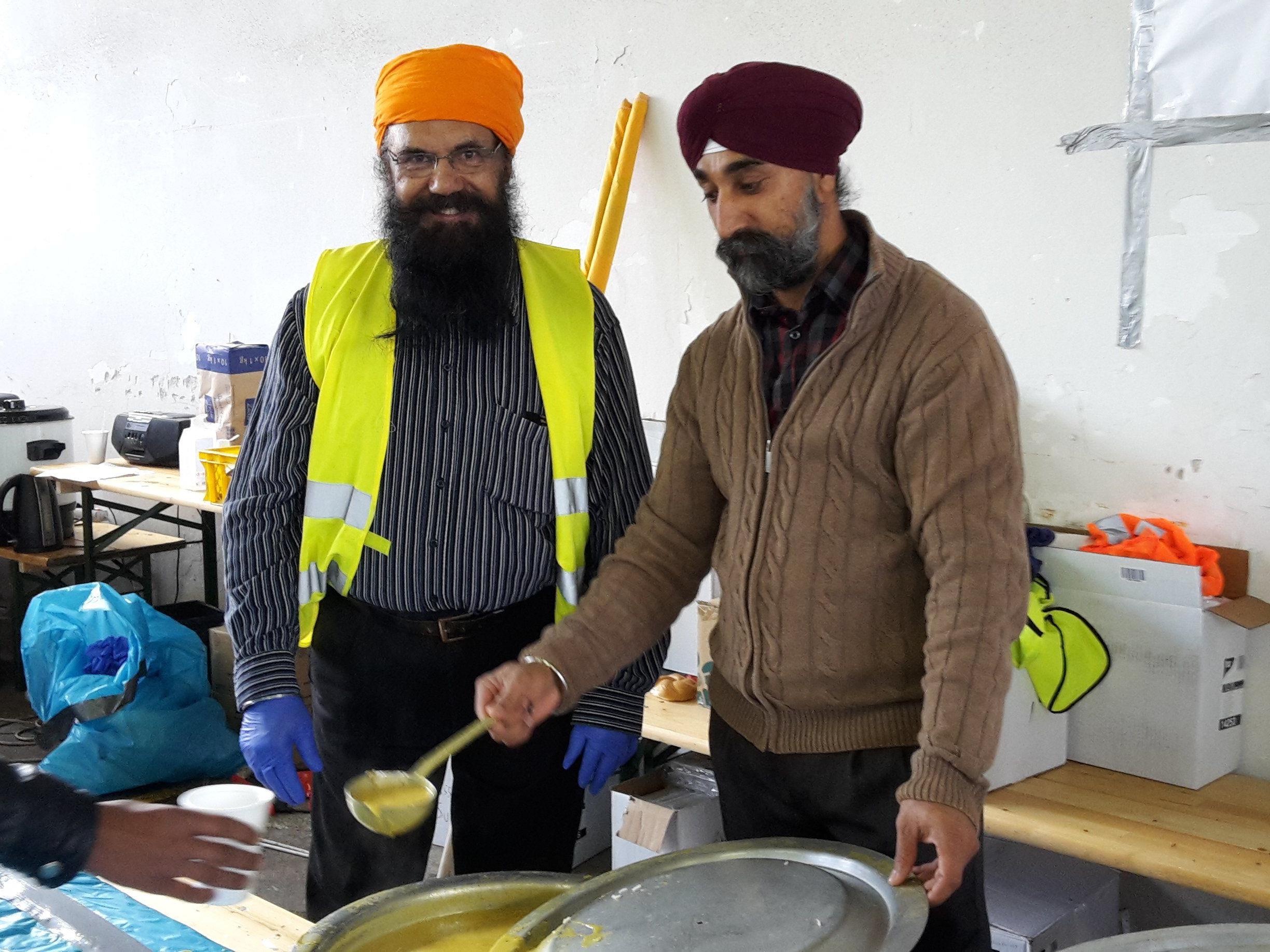 Singh Amritpal und ein weiteres Mitglied Sikhtempels in Salzburg-Gnigl teilen Essen an die Flüchtlinge aus.