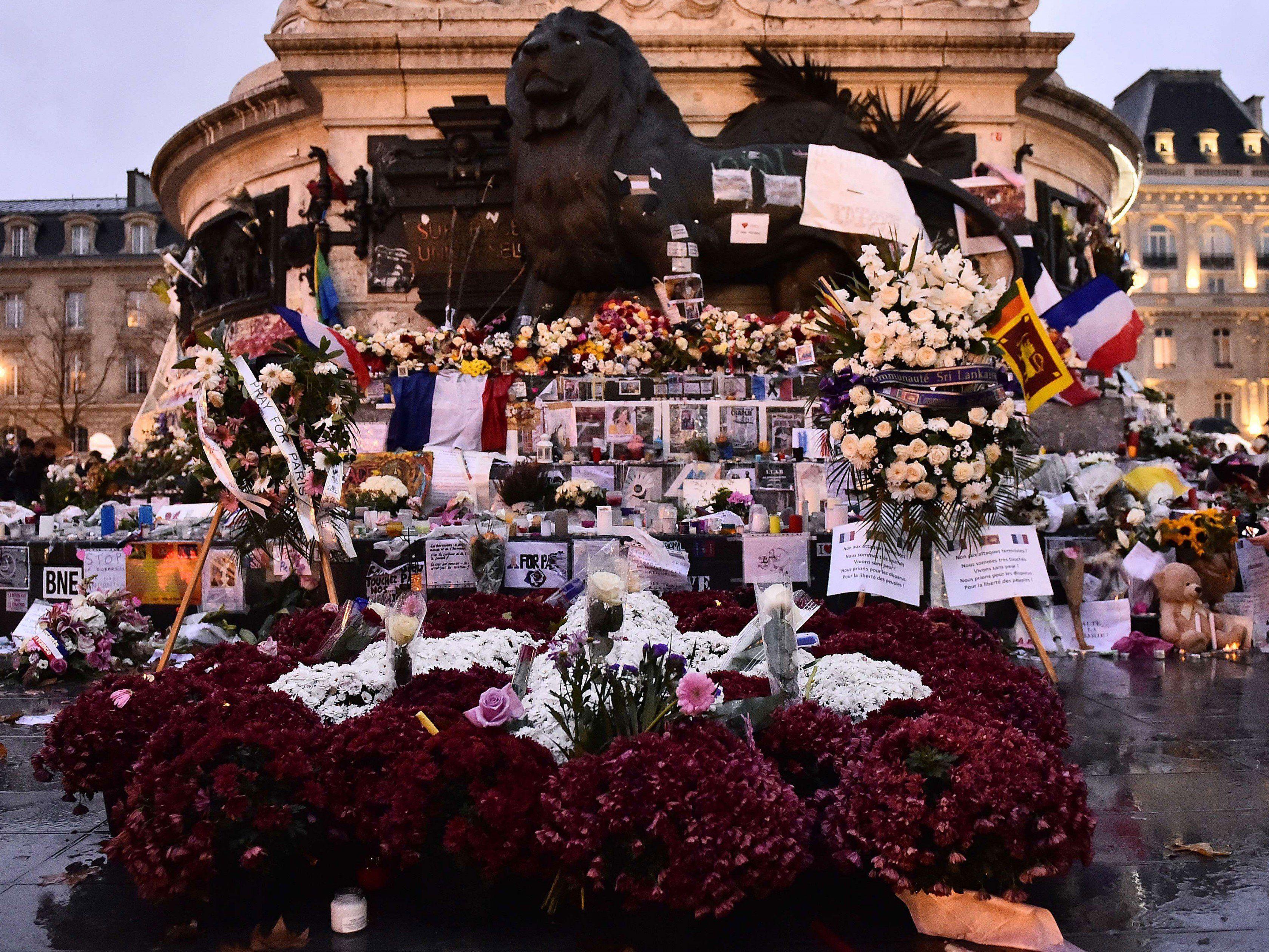 Blumen, Kerzen und Nachrichten nach dem Terror in Paris am Place de la Republique.