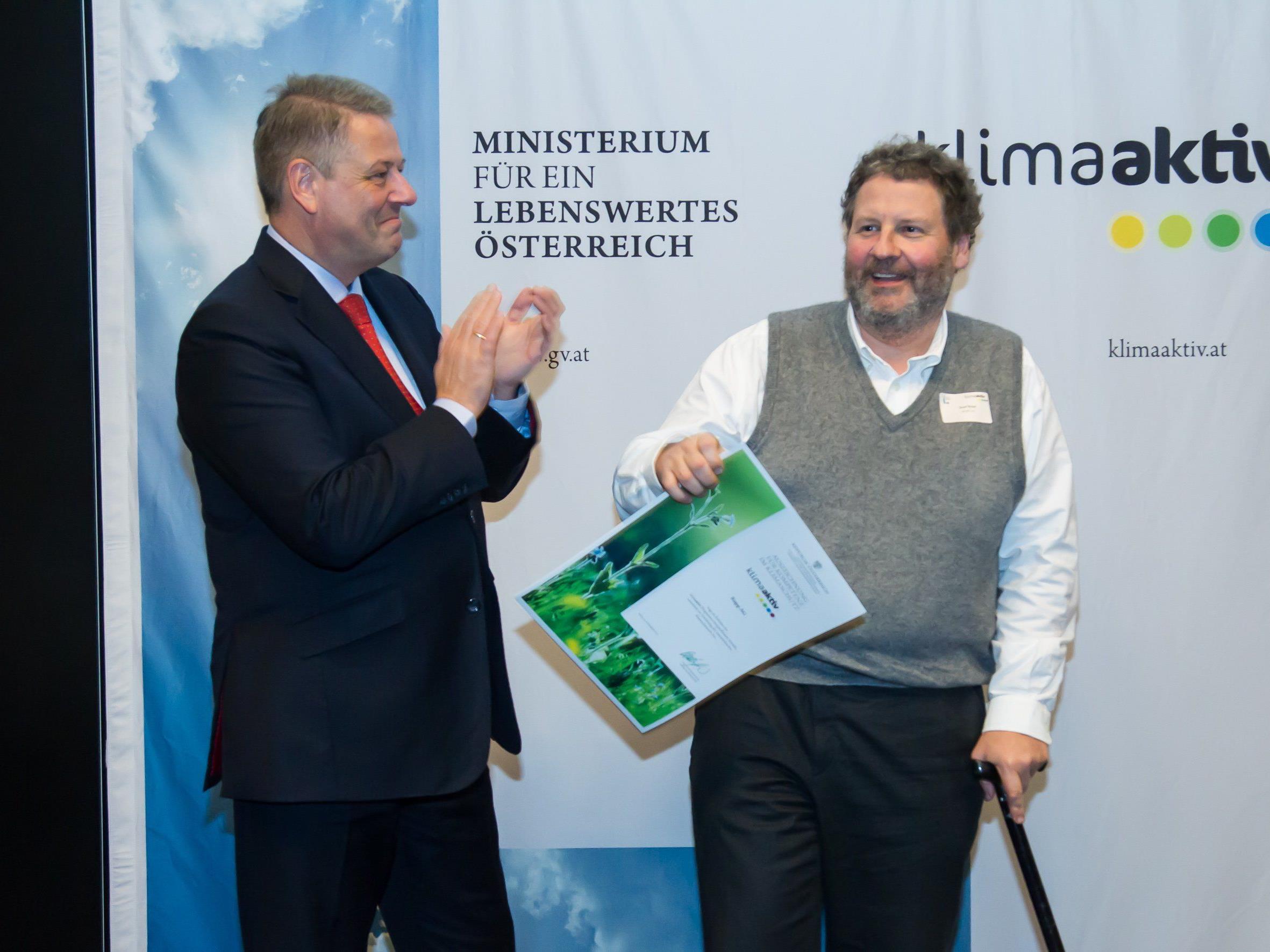 Umweltminister Andrä Rupprechter übergibt Vorstandsvorsitzendem Josef Rupp die Auszeichnung für "Kompetenz im Klimasschutz".