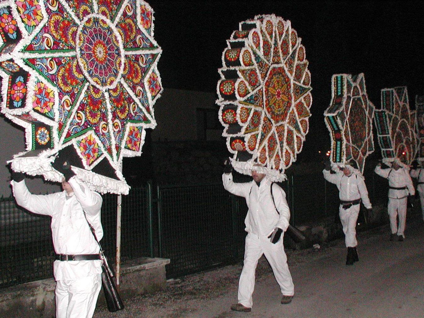 "Glöckler" in weißen Gewändern und mit großen Kappen - bebildert mit traditionellen Motiven - und Schellen treiben in der letzten Raunacht vor dem Dreikönigstag die bösen Geister aus.