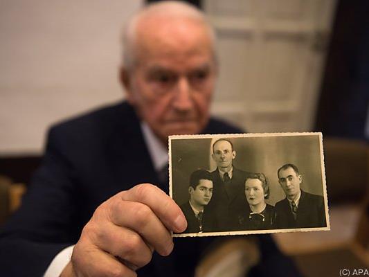 Angehörige zeigen Fotos von Opfern des KZ in Auschwitz