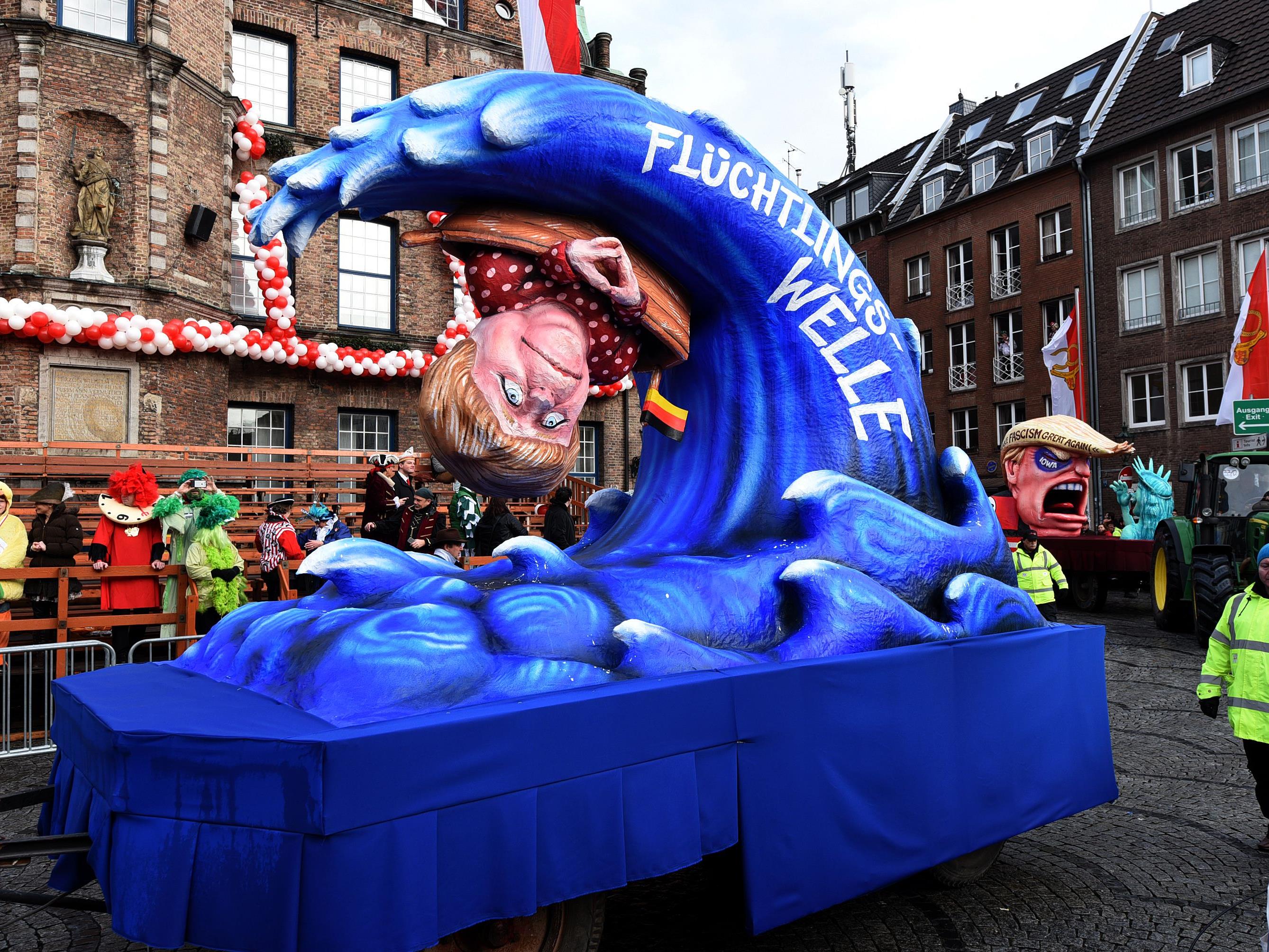 Ein Karnevalwagen in Düsseldorf greift Angela Merkels Flüchtlingspolitik auf.