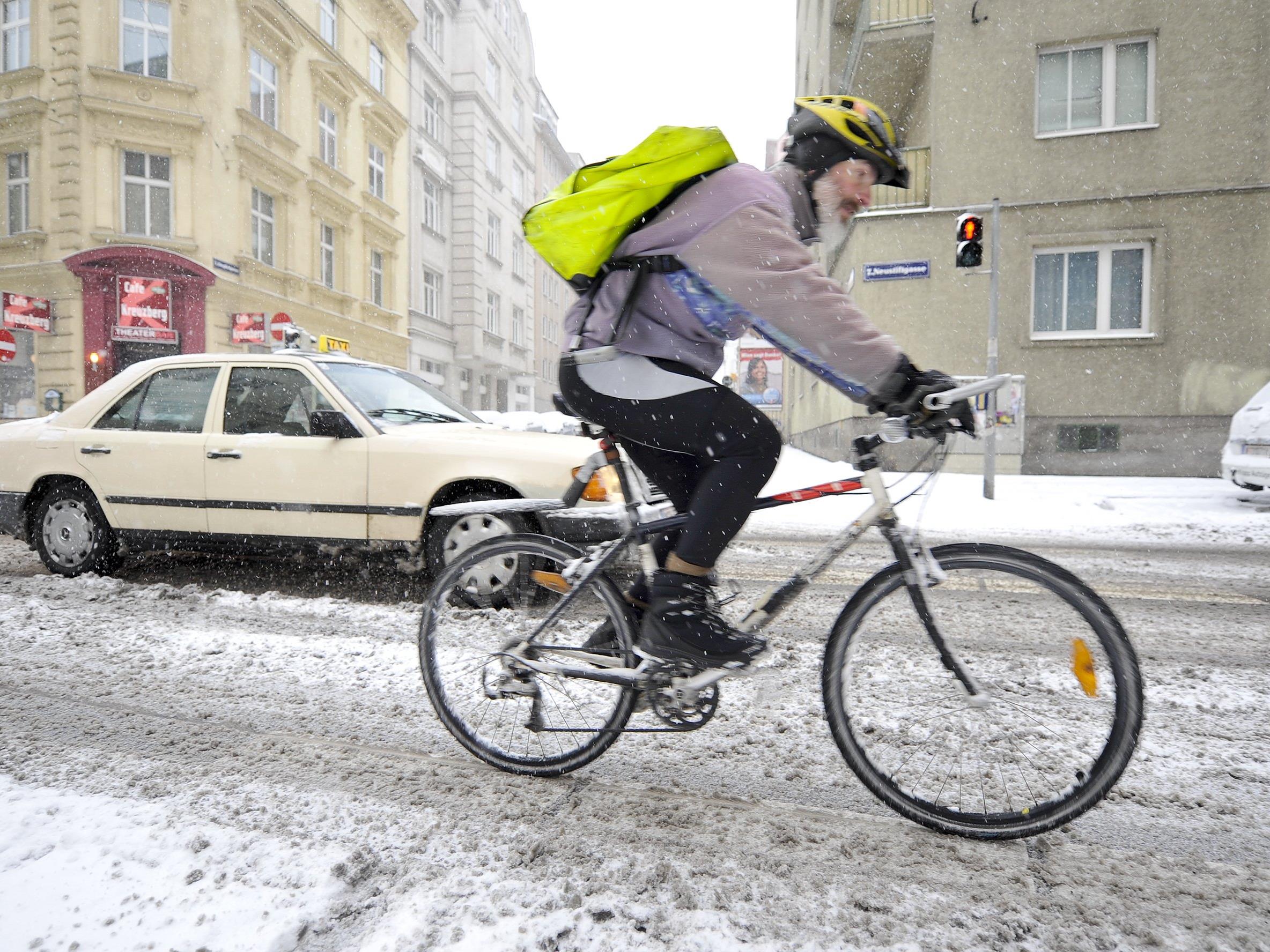 Ein Wiener Fahrradbote kämpft sich durch den Schnee.