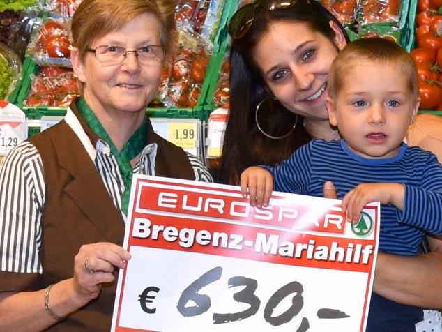 Marktleiterin Sigrid Vögel (links) bei der Scheckübergabe an den kleinen Dario und seine Mutter