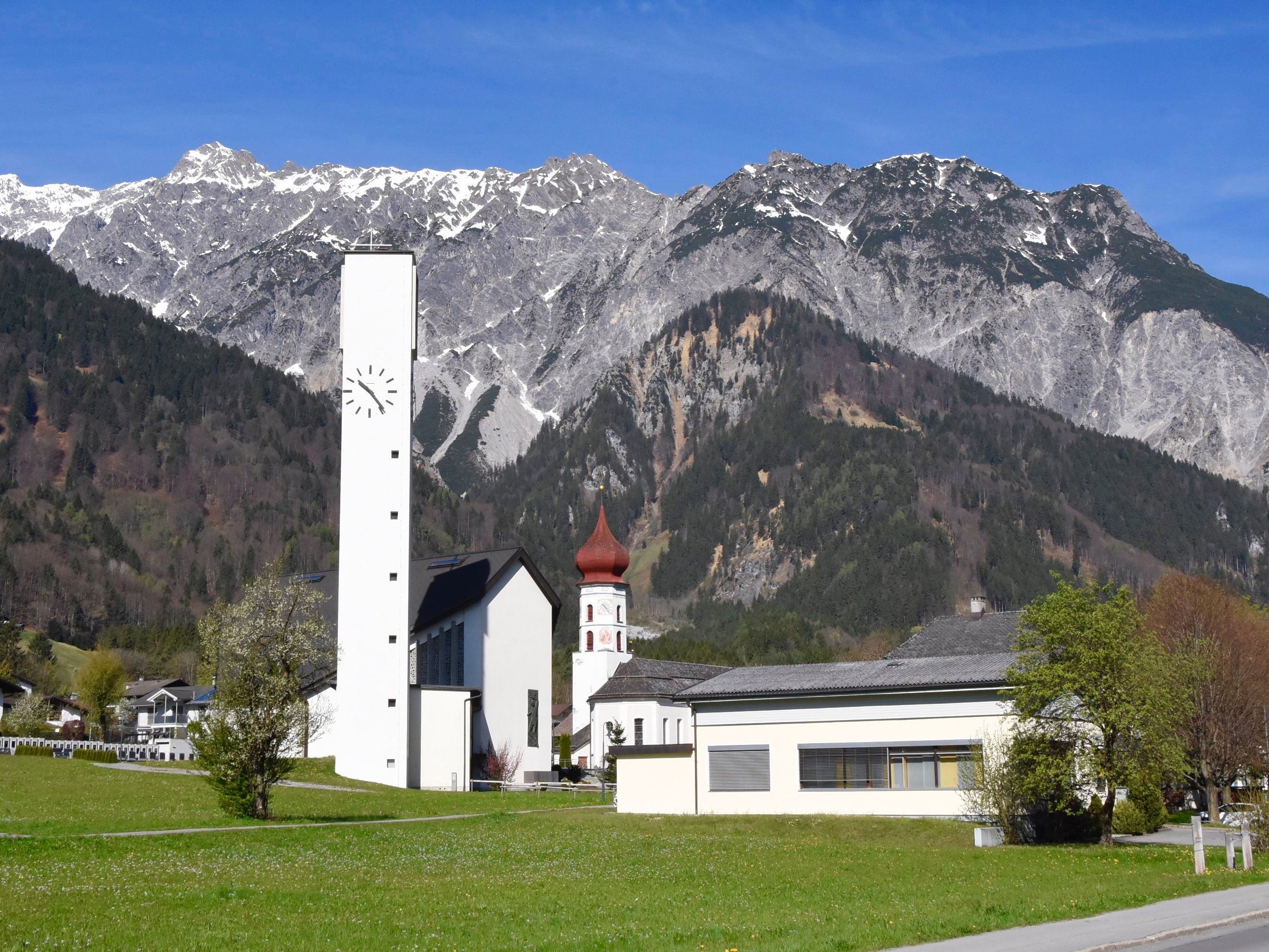 Neue und Alte Pfarrkirche Vandans mit Vandanser Steinwand in einer Aufnahme vom Mittwoch vor Ostern 2017