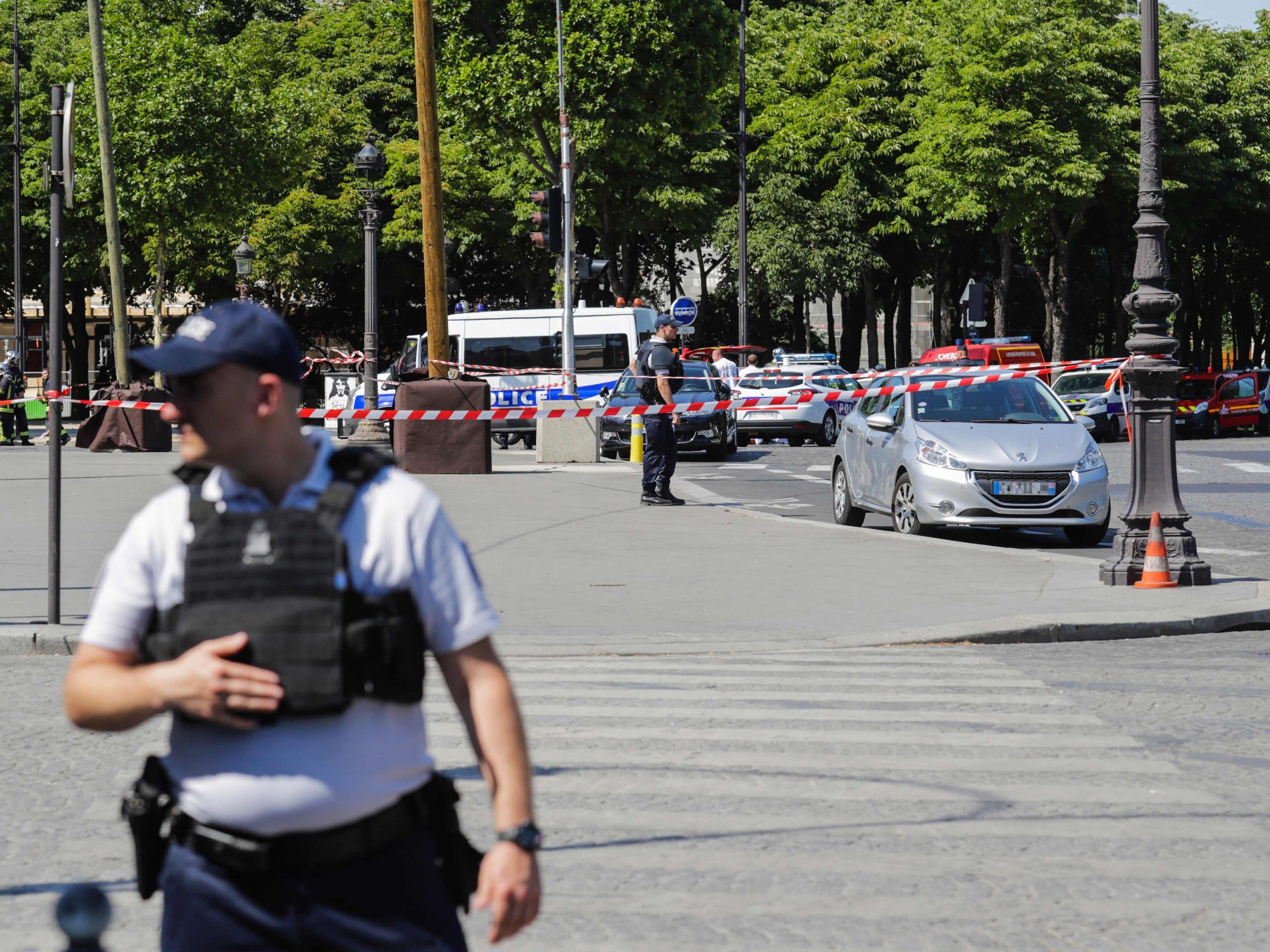 Auf der Pariser Champs-Elysees fuhr ein bewaffneter Mann in ein Polizeiauto.